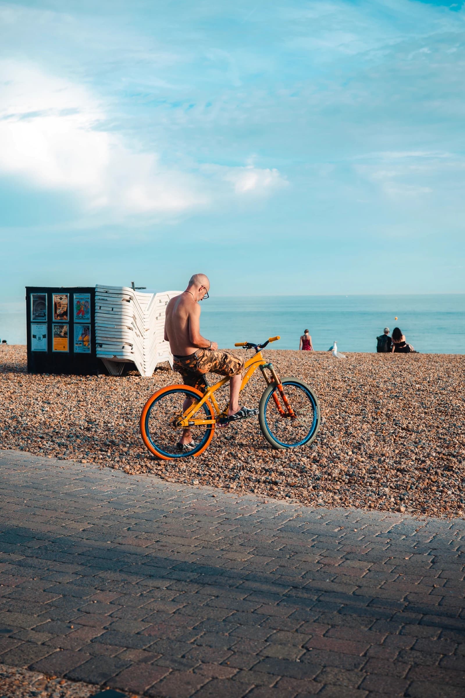 A cyclist on a painted bike on Brighton beach, edited with the Made in Brighton pack