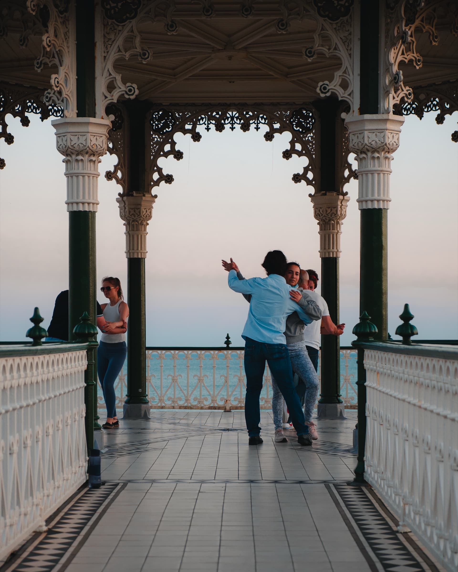 People dancing in the Brighton Bandstand at dusk